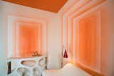 Decorative artist Willem Racké worked with Susan Chastain to create this vibrant tangerine lounge. The two main walls of the small room were painted to give the illusion of looking into infinity. A high-gloss, orange lacquer covers the ceiling.&nbsp;