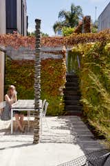 Outdoor, Concrete Fences, Wall, and Garden In the ivy-covered garden on the first level, Alice, 16, sits near “Rakaia 2,” a rock sculpture by New Zealand artist Chris Booth.  Photos from This New Zealand Architect Created a House That Looks Like a Tiny Village