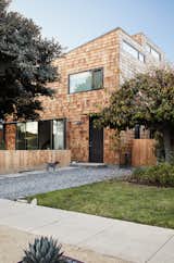 The black door and window frames provide a contrast to the cedar siding.