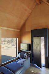 Living Room, Concrete Floor, and Sectional The house has smart locks by August, Caséta wireless controls by Lutron, and a hub security system by Scout.  Photo 9 of 13 in These Tiny, Off-the-Grid Cabins Near Joshua Tree Look Totally Apocalypse-Proof