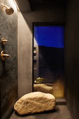 Bath Room, Full Shower, and Accent Lighting A large rock from the property provides seating in the shower.  Search “full spectrum josef albers” from These Tiny, Off-the-Grid Cabins Near Joshua Tree Look Totally Apocalypse-Proof