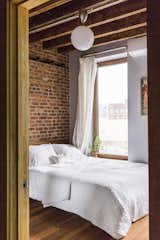 Bedroom, Bed, Ceiling Lighting, and Medium Hardwood Floor The guest room features a bed from West Elm.  Linda Foster’s Saves from In Brooklyn, an 1890s Townhouse Is Reborn With Tons of Light and a Crisp Black Facade