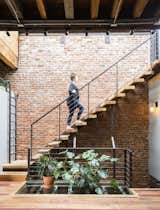 Staircase, Wood Tread, and Metal Railing Next to the steel-and-wood staircase, which leads to the roof, a patch of glass flooring lets sunlight filter down to the bedrooms.  Photo 4 of 5 in In Brooklyn, an 1890s Townhouse Is Reborn With Tons of Light and a Crisp Black Facade