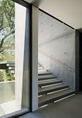 The stair treads are structural steel clad in stone over a steel plate stringer created by West Edge Metals.