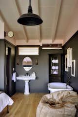 Bath Room, Medium Hardwood Floor, Freestanding Tub, Pedestal Sink, Pendant Lighting, and Wall Lighting  Photo 14 of 15 in The Montauk Beach House by Dwell
