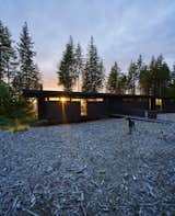 Exterior, Flat RoofLine, Metal Siding Material, and House Building Type In Carnation, Washington, Kim and Lou Maxon and their three boys reside in a horizontal, steel-clad house designed by the renowned firm Olson Kundig. Its south end is slightly raised above the bare landscape, accessible via a bridge.   Photo 1 of 18 in A Seattle-Area Family Breaks Free From Suburbia and Ventures Deep Into Nature