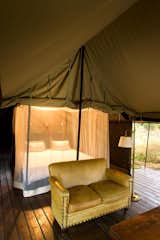 Bedroom, Bed, Floor Lighting, and Dark Hardwood Floor  Photo 3 of 12 in Honeyguide Tented Safari Camps by Dwell