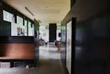 Hallway and Concrete Floor The oak-colored custom built-in entry bench by Schuchart | Dow provides a welcoming contrast to the dark steel baseboards by Alpine Welding that cut the space vertically.  Photos from A Seattle-Area Family Breaks Free From Suburbia and Ventures Deep Into Nature