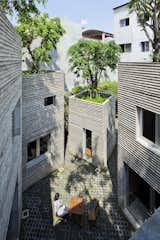 Outdoor, Rooftop, Trees, and Grass The external walls are made of in-situ concrete with bamboo formwork.  Photo 6 of 20 in A Concrete Home in Vietnam Is Topped With Trees