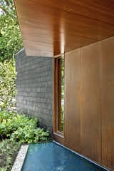 Bluestone slabs lead across a pair of reflecting ponds to the sapele mahogany front door.