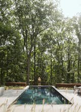 Outdoor, Trees, Shrubs, Large Patio, Porch, Deck, Back Yard, and Swimming Pools, Tubs, Shower In back, the swimming pool abuts a steep drop-off.  Photos from After a Fire, a Maryland Couple Turn to Charred Wood to Rebuild Their House