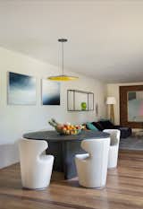 Dining Room, Medium Hardwood Floor, Pendant Lighting, Recessed Lighting, Table, and Chair In a separate wing, the residents enjoy a private TV-room and dining area.  Photo 7 of 8 in This Breezy Brazilian Home Oozes Tropical Vibes