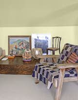 An Adirondack-style chair covered in a vintage quilt sits in one corner.