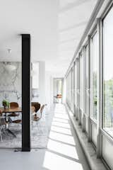 Dining Room, Pendant Lighting, Table, Rug Floor, and Chair The drafty windows on the south facade all had to go. “That alone cost more than my previous house,” says Simon. “The heritage people wanted the glass to have the same shine and coloration.”  Photos from A Major Restoration Updated This Midcentury Landmark in Belgium