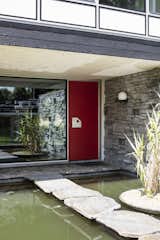 Doors, Exterior, and Swing Door Type Bluestone slabs float across the reflecting pond, which was inspired by Engels’s travels in Japan.  Photo 12 of 38 in A Major Restoration Updated This Midcentury Landmark in Belgium