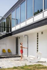 Outdoor, Back Yard, Large Patio, Porch, Deck, Shower Pools, Tubs, Shower, and Grass A Voido rocker by Ron Arad for Magis sits by the outdoor shower, also new.  Search “blue-concentrate-shower-curtain-ring.html” from A Major Restoration Updated This Midcentury Landmark in Belgium