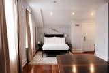 Bedroom, Night Stands, Dark Hardwood Floor, Rug Floor, Wall Lighting, and Bed  Photo 14 of 15 in Henry Howard Hotel by Dwell