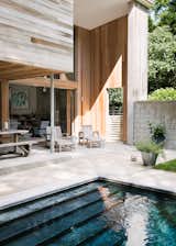 Outdoor, Concrete Patio, Porch, Deck, Swimming Pools, Tubs, Shower, and Back Yard Wood, stone, and concrete create a sense of welcome and warmth.  Photo 8 of 10 in New York Architect John Berg Invites Us Into His Indoor/Outdoor Hamptons Home