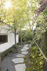 Katsura trees, climbing hydrangeas, and basalt stepping stones create a pleasing passageway between the lower back deck and the new garage. “What could have been leftover space, I wanted to be a promenade,” says Andrea.