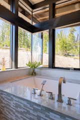 In the master bath, a zero corner window allows the homeowners to soak in views of the wilderness.