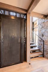 A steel elevator, wrapped by a staircase, anchors the home and descends downstairs to the bunk room.&nbsp;