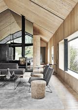 Living, Medium Hardwood, Coffee Tables, End Tables, Two-Sided, Sofa, Chair, and Wood Burning Scott set the windows into deep recesses.  Living Wood Burning Chair Medium Hardwood Photos from A Hotelier Riffs on a Traditional Barn for His Family’s Retreat in South Africa