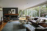 The living room is furnished with an Eames lounge and ottoman and a Line credenza by Nathan Yong. The fireplace, also painted by the last owner, is Wrought Iron by Benjamin Moore.