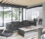 Living Room, Chair, Coffee Tables, Sofa, Rug Floor, and Floor Lighting In the living room, a B&amp;B Italia sofa and chair and Arco Floor Lamp rest on a Beni Ouarain rug.  Photo 5 of 12 in A Stone Retreat in France Gets a Sleek Glass Addition