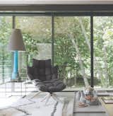 Living Room, Table Lighting, Coffee Tables, Chair, and Rug Floor A Husk Armchair by Patricia Urquiola provides a cozy perch. The table lamp is made from an old boat mast, and the gray ceramics are also by Vipp.  Photo 9 of 12 in A Stone Retreat in France Gets a Sleek Glass Addition