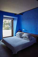 In a guestroom in Villa 1, an original 1970s bed by Fagnola is paired with a new Tab T lamp by Flos and Yves Klein blue walls.