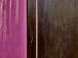 All across the property, blocks of jewel-toned color meet raw materials, like a hot pink concrete wall next to a Cor-Ten steel door with a rebar handle.  Photos from An Architect Unites Three Brutalist Villas He Designed on Sardinia in the 1970s