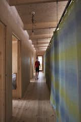 Hallway and Light Hardwood Floor A Cassano fabric drape for Designers Guild runs the length of the family’s sleeping pavilion, one of three volumes that make up the house. Behind it is a storage system by Elfa.  Photos from A Pint-Sized, No-Frills Summerhouse Rises From the Rocks on a Swedish Island