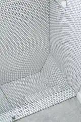 Penny tiles from Daltile line a sunken shower.