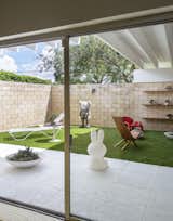 Outdoor, Small Patio, Porch, Deck, and Grass KAWS Companion Figure.  Photo 16 of 25 in The Ellison House by Dwell from Pop Art, Street Art, and Space-Age Furniture Collide at a Painter’s Midcentury Ranch Home in Florida