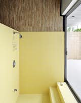 Bathroom Tile: The side-by-side bathrooms look out on a private courtyard through floor-to-ceiling sliding glass doors. They feature original tile in the sunken showers—one in butter yellow, the other in light gray. “The tiles are heavy, real chunky, and of the period,” says Christopher. He had them completely restored, working alongside the tilers and filling cracks with a porcelain paint pen for two days straight. “For something from 1963, they’re really in immaculate shape,” he says.