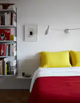 Even the bedding adheres to the color scheme, with yellow pillows from Merci in Paris and a red blanket from Best Made. The sconce is by David Weeks Studio.