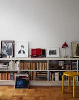 A red Crosley turntable sits on top of a custom shelving unit in the living room. The use of primary colors, also seen in the yellow Stool 60 by Alvar Aalto, is a nod to the Bauhaus, says Luise.