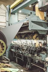 10. Trim and Finish: After being spun onto a large metal spool, the master roll is either sold whole or trimmed into smaller units  by the slitter, seen here. The embosser may then add a decorative finish, like leather, linen, felt, or fabric.