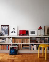 Living Room, Medium Hardwood Floor, Shelves, and Table Lighting A red Crosley turntable sits on top of a custom shelving unit in the living room. The use of primary colors, also seen in the yellow Stool 60 by Alvar Aalto, is a nod to the Bauhaus, says Luise.  Search “성북휴게텔【Opss 60。컴】성북리얼돌 ↘오피쓰 ↙성북휴게텔 성북키스방 ⛳성북휴게텔 성북휴게텔 성북스파” from Two Magazine Creatives Fit Graphic Art and Vintage Furniture in a Brooklyn Apartment