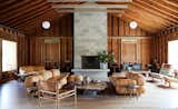 Living Room, Pendant Lighting, Light Hardwood Floor, Chair, Coffee Tables, Standard Layout Fireplace, Rug Floor, and Sofa  Photo 2 of 8 in Tourists by Dwell