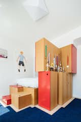 Kids, Pre-Teen, Bed, Boy, Rug, Storage, Bedroom, and Light Hardwood In the boy’s room, Dash Marshall designed a platform bed and multiple storage units, accented with red lacquer and arranged in a playful way. “They’re built-ins, but we didn’t want them to look like built-ins,” says firm principal Ritchie Yao. “They’re more like stacked boxes.”  Kids Bedroom Bed Boy Light Hardwood Photos from A California Couple Give a Cookie-Cutter Brooklyn Condo Some Personality