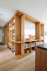 Custom white oak shelving separates the media/guestroom from the kitchen.