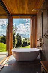 The master bathroom has a floor-to-ceiling windowed corner that holds a Belle freestanding tub by Progetto and in-wall fixtures by Copper Bath.