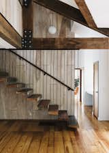 Floating against birch paneling, the main stair incorporates treads salvaged from old barn wood.