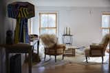 Vintage armchairs covered in sheepskin are arranged around a crate table on the second floor. 