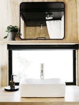 The bathroom’s plywood counter, which supports a vessel sink by Fine Fixtures, has a matte polyurethane finish; the flower pot is by Hay and the mirror is from Target.