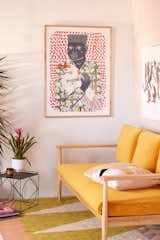 This trendy living room features an Urban Outfitters-exclusive print from artist and illustrator Camilla Perkins. Her work Gentleman With Egret inspired by renaissance portraiture in an ode to the vibrant textiles of the Congo's sapeurs.