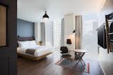 Bedroom, Chair, Rug Floor, Wall Lighting, Bed, Dark Hardwood Floor, Ceiling Lighting, and Floor Lighting  Photos from Moxy Osaka Honmachi