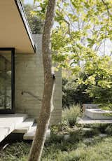 Steps lead from the master bedroom balcony to a spacious deck. Situating the deck away from the house gives it the feel of a getaway, says Trainor, who worked on the project with colleague David LeRoy. “We liked the idea of going further into the garden amid plantings for privacy,” adds Trainor. Granite boulders and persimmon, Japanese maple, and oak trees lend what he calls “a California-Japanese feel.”