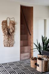 Nichols also made the steep stairwell leading up from the entryway. The straw garment on the wall is a <i>mino</i>, a traditional Japanese raincoat.
